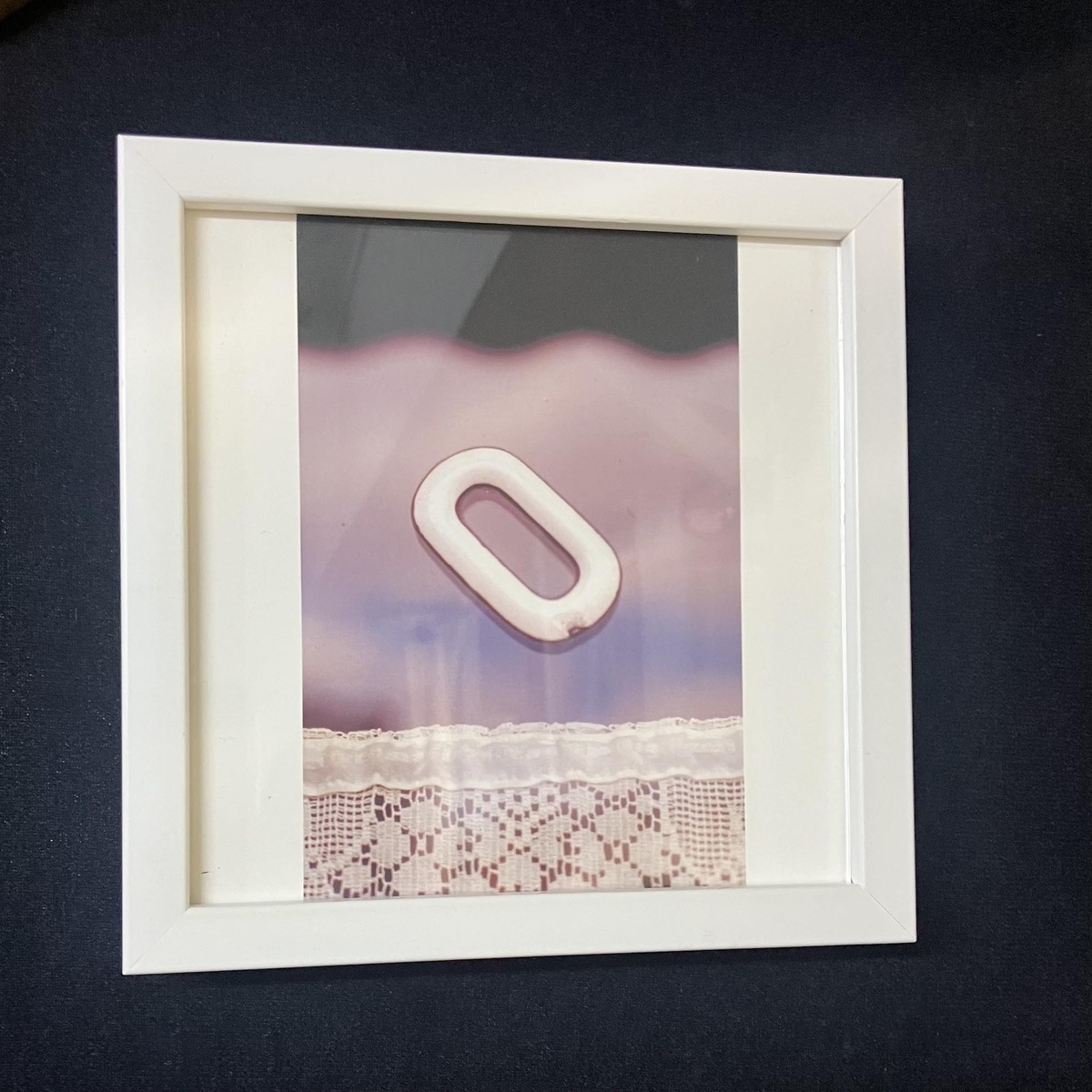 白い額縁で額装して黒の壁面に飾る